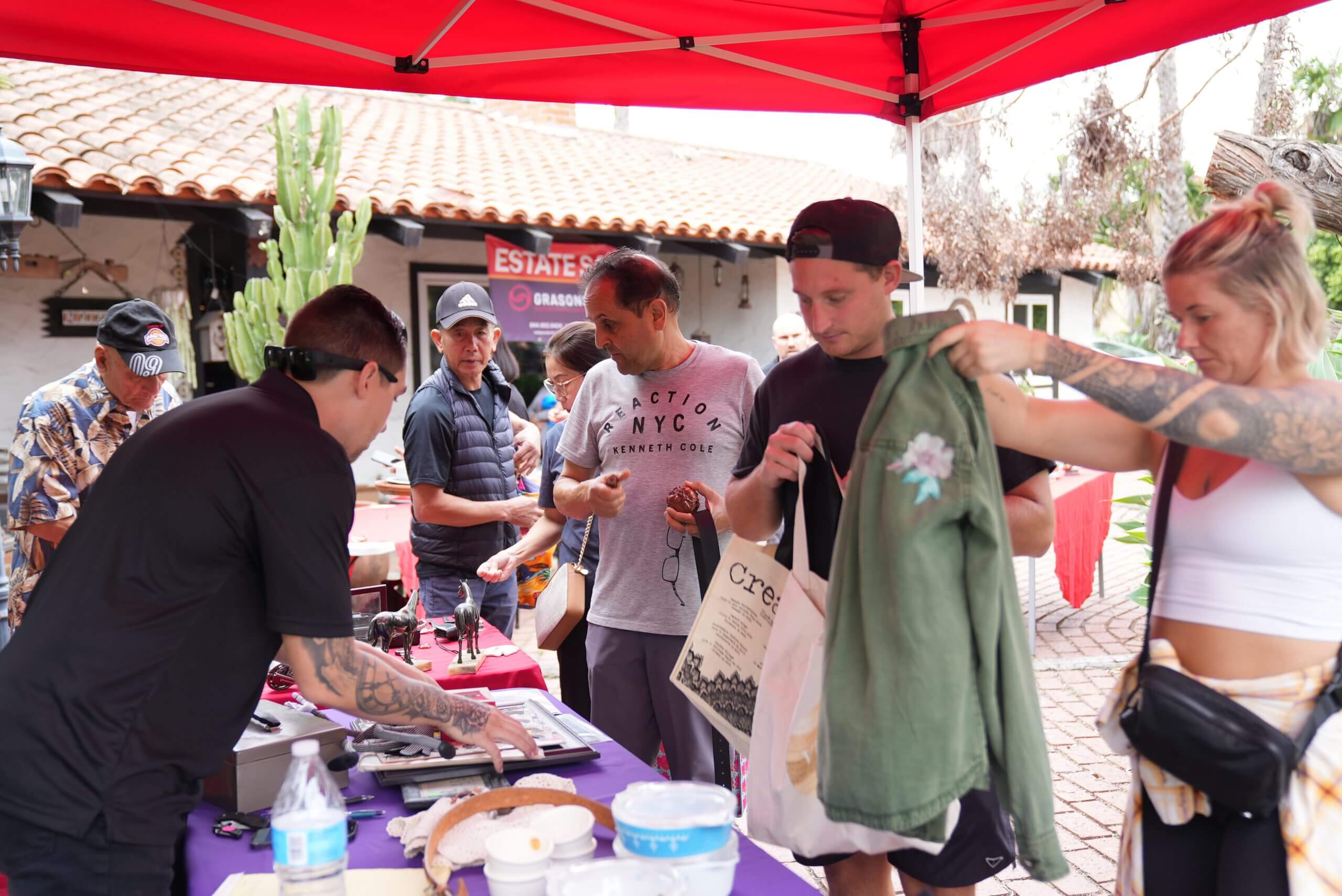 An employee of Grasons operates a check-out booth at an estate sale.